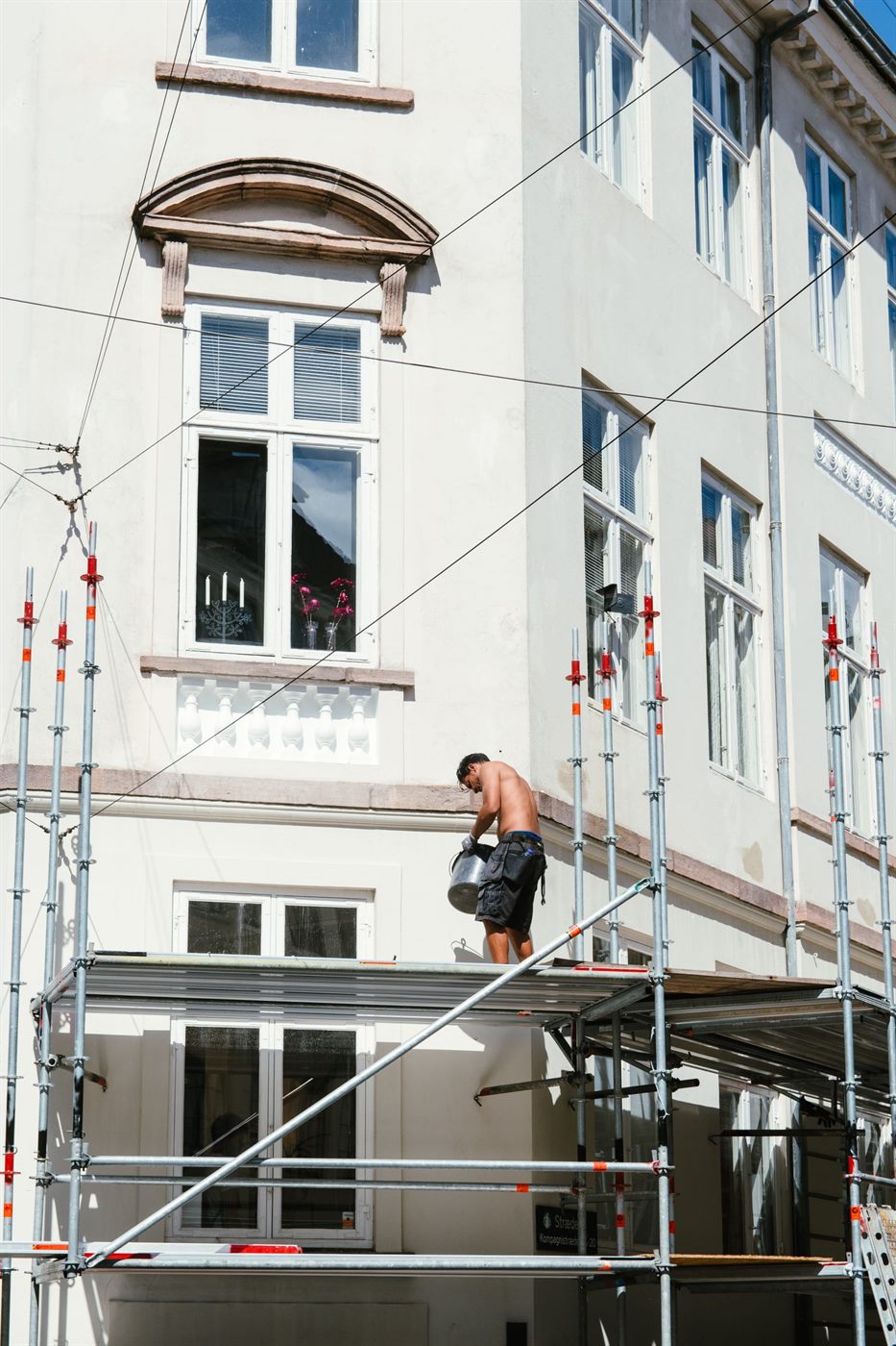 Vakman werkt vanaf een steiger aan de gevel van een woning