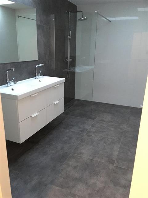 Wastafelmeubel met natuurstenen wasblad in een gerenoveerde badkamer