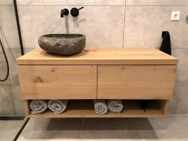 Wastafelmeubel met natuurstenen wasblad in een gerenoveerde badkamer