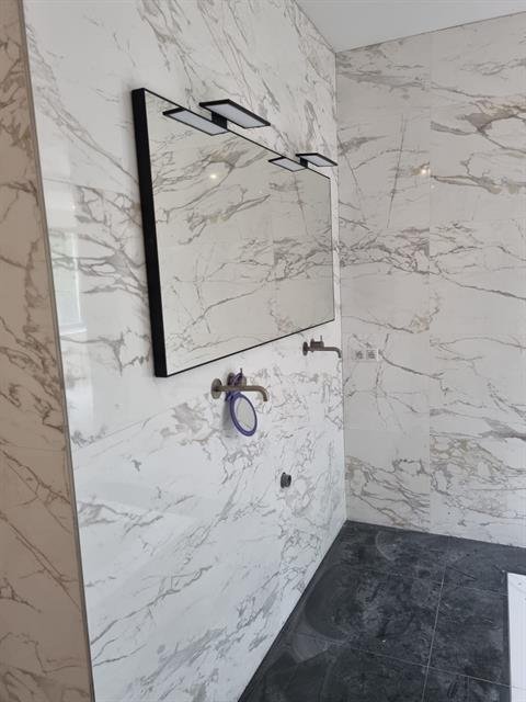 Wastafelmeubel met natuurstenen wasblad in een gerenoveerde badkamer