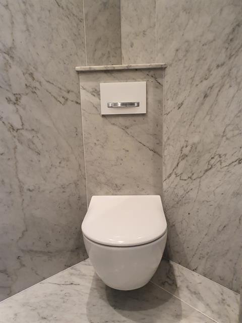 Badkamer met marmerlook tegelwerk op wand en vloer